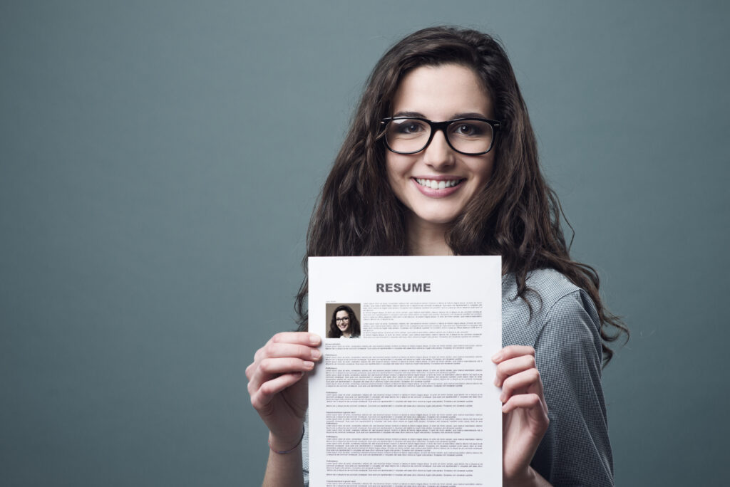 young cheerful female holding her resume 
